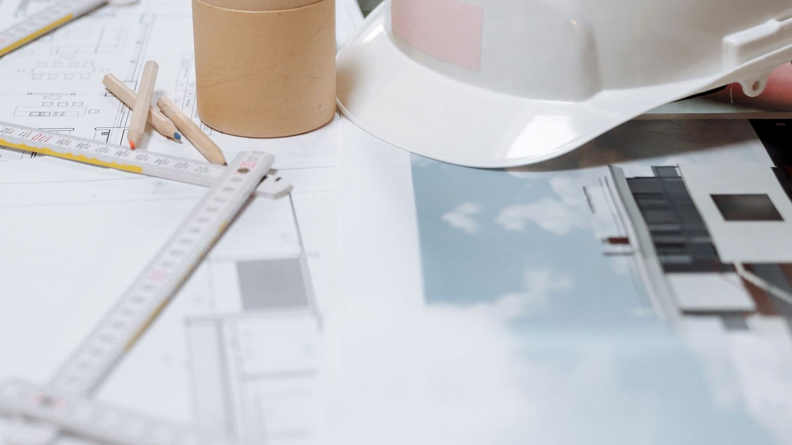 Public owner's representative site office desk with project plans and a hard hat, where surety bond verification and public owner bond acceptance begin before award